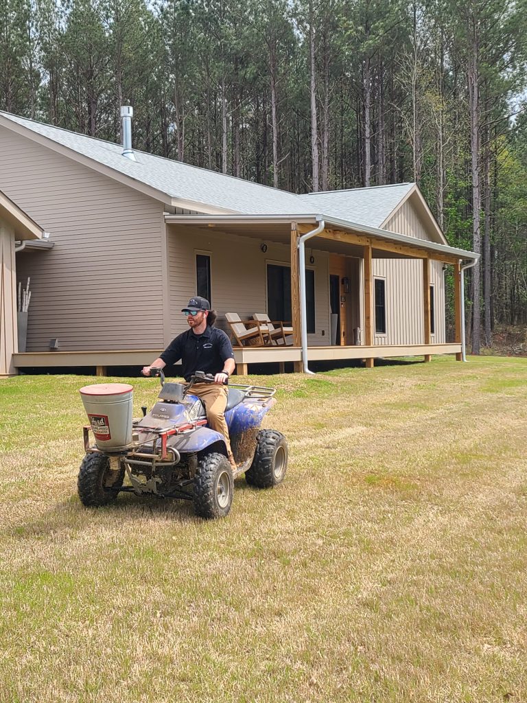 team member spreading pest control treatment on a lawn